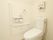 トイレは床がフローリング仕様で、洋式タイプである。L字型の手すりが設けられ、安心して身体をあずけることができる。