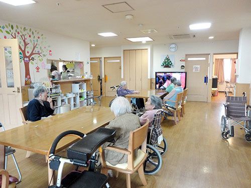 テレビやテーブルセットが置かれた共有スペースでくつろぐ入居者の様子。