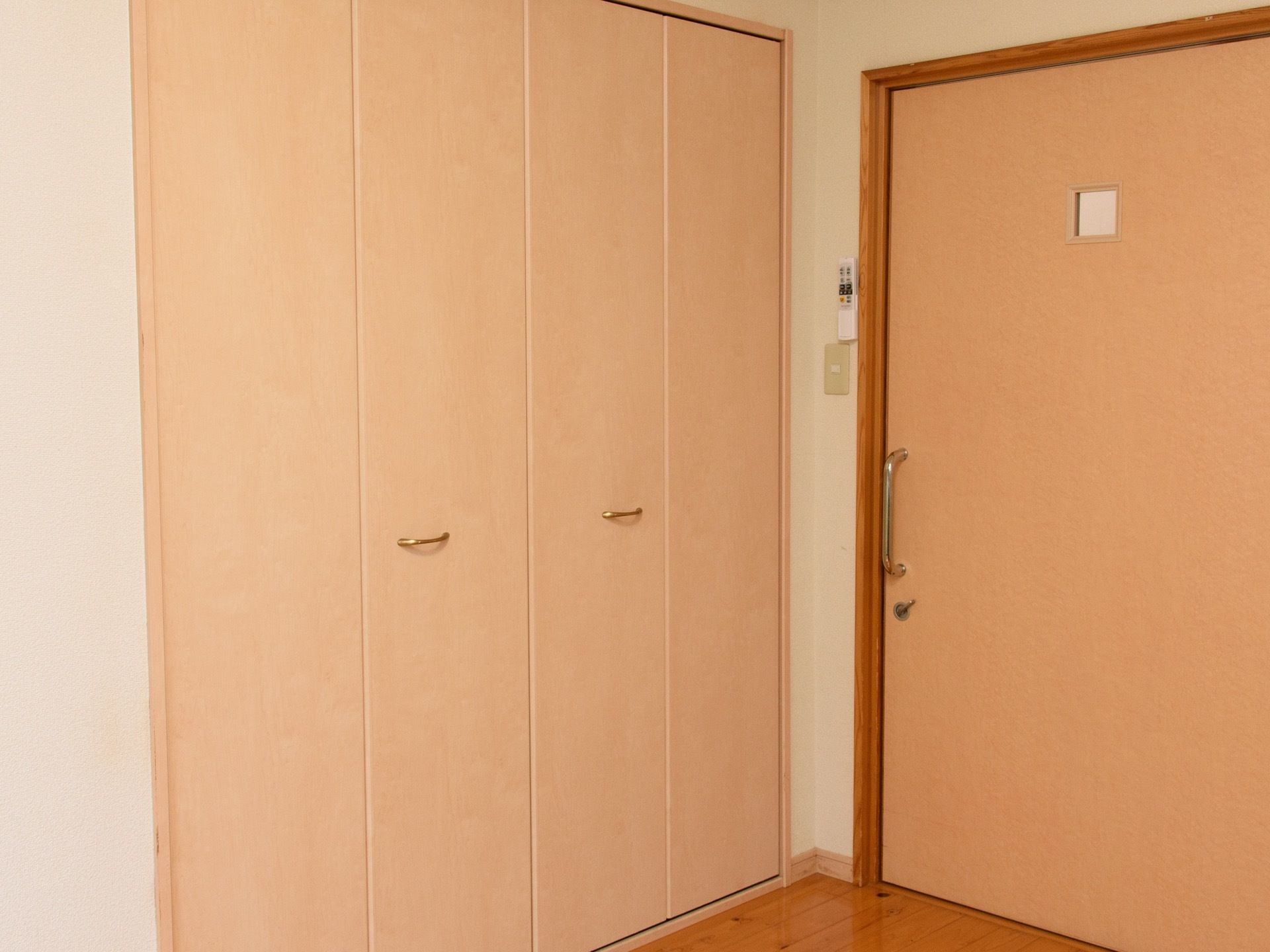 居室入口は、上部に小さな四角いすりガラスが入った引き戸である。入ってすぐの所に観音開きの扉がついた収納スペースがある。