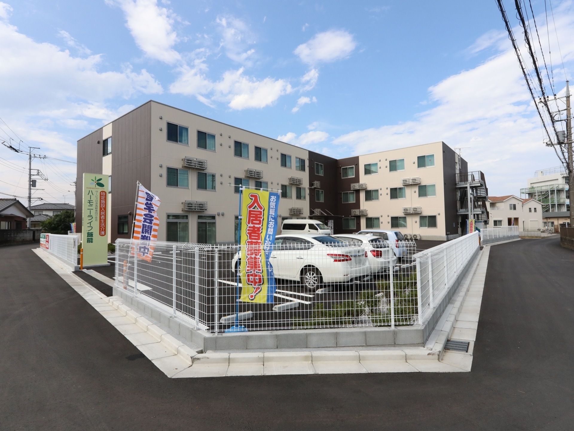 ベージュ色が基調の落ち着いた雰囲気の建物である。3階建てになっており、建物の前には広々とした駐車場が確保されている。