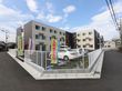 ベージュ色が基調の落ち着いた雰囲気の建物である。3階建てになっており、建物の前には広々とした駐車場が確保されている。