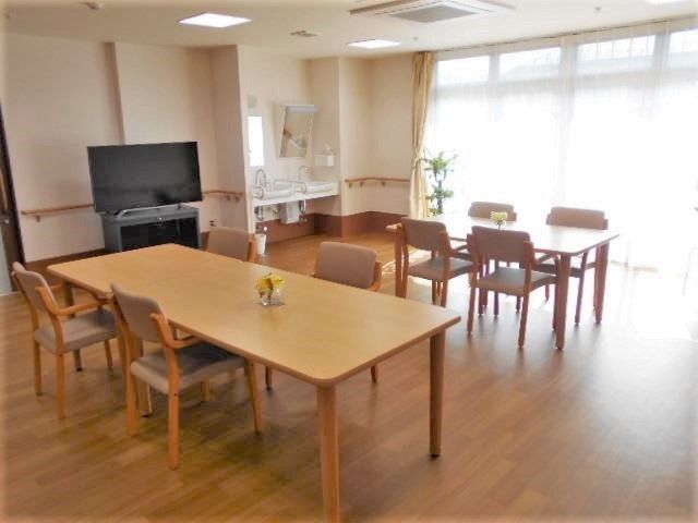 大きなテレビが付いたリビングダイニングには木製のテーブルが二つあり、大きな窓もる。