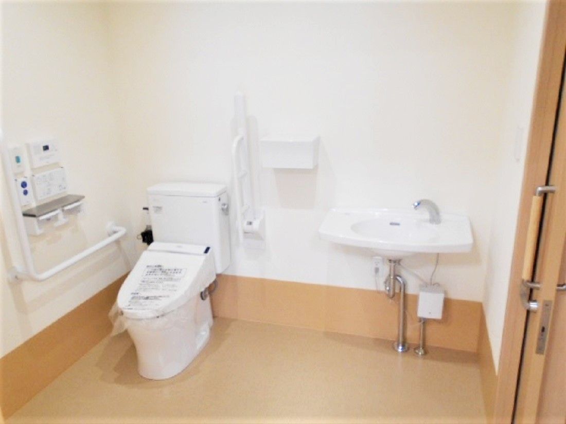 介助スペースも十分あるトイレには手すりが複数付き、緑色の呼び出しボタンもある。