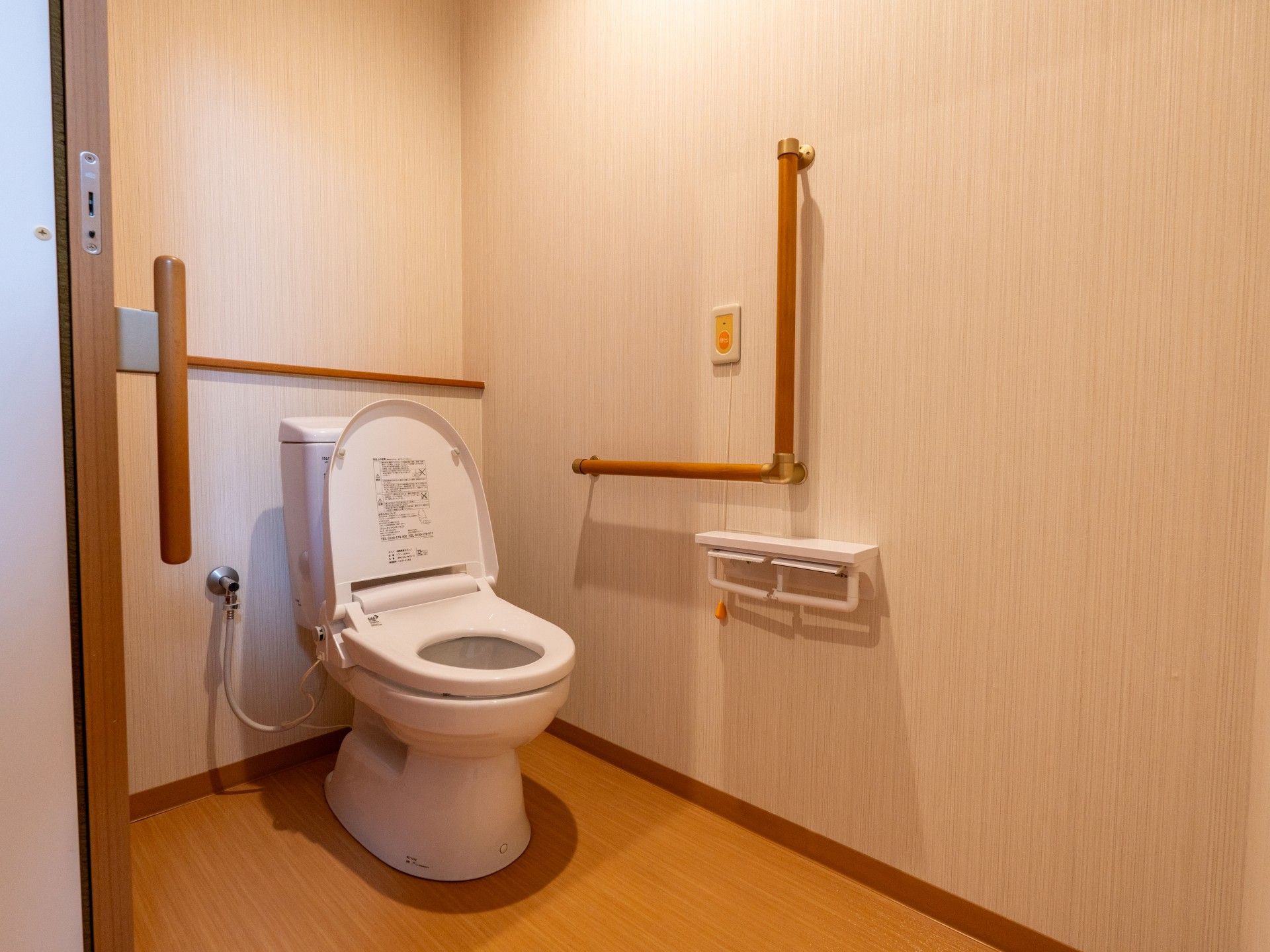 車椅子に座った高齢女性の手を取る女性ヘルパー