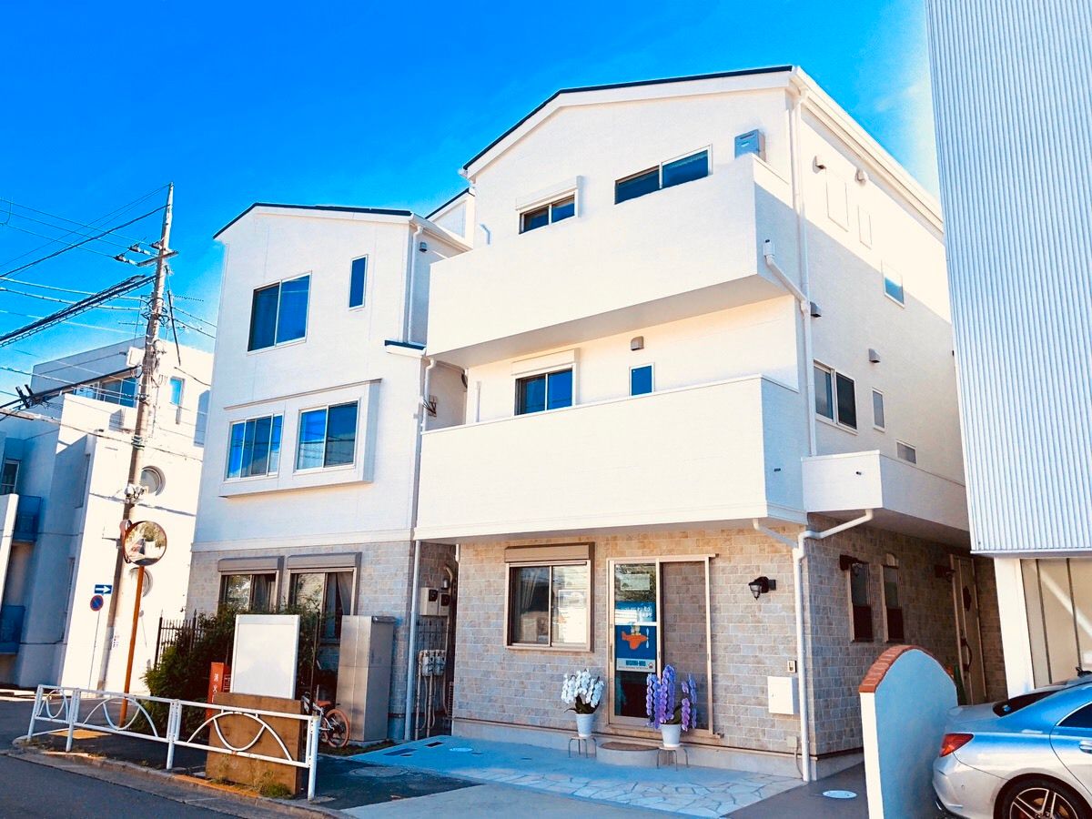 白い壁を基調にした３階建ての建物の様子。オーナーズテラスの外観写真