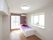 白と紫で構成された部屋である。部屋の角に白いベッドが置かれており、紫色のベッドカバーがかけられている。