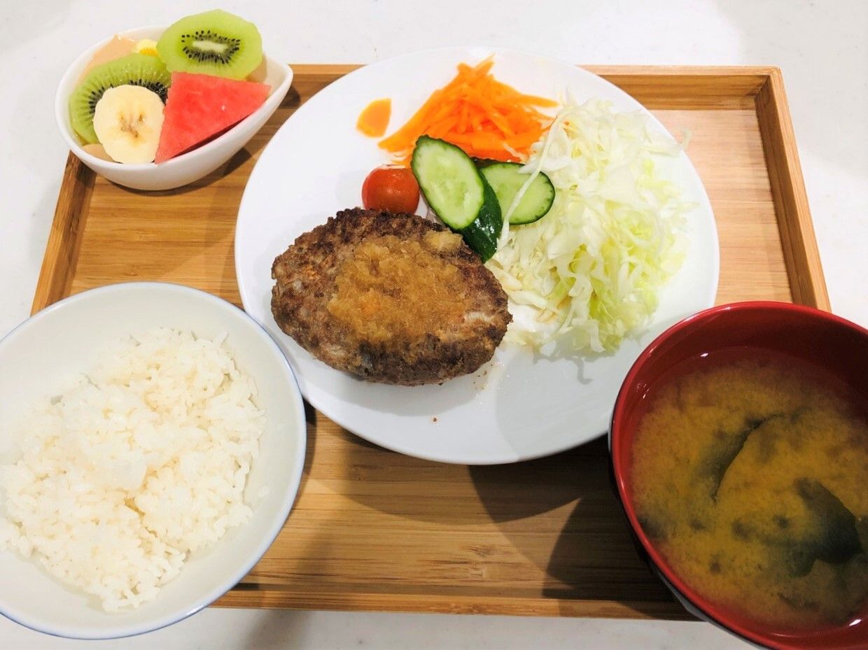 揚げ物とサラダがワンプレートに盛られたフルーツ付きの食事