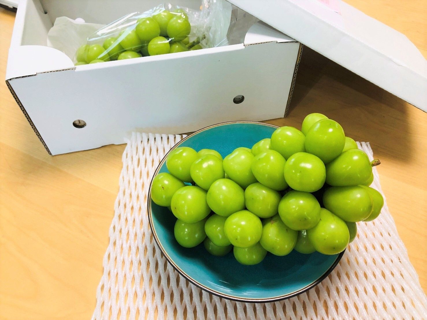 つやつやして大玉の粒がついているマスカットが乗った皿