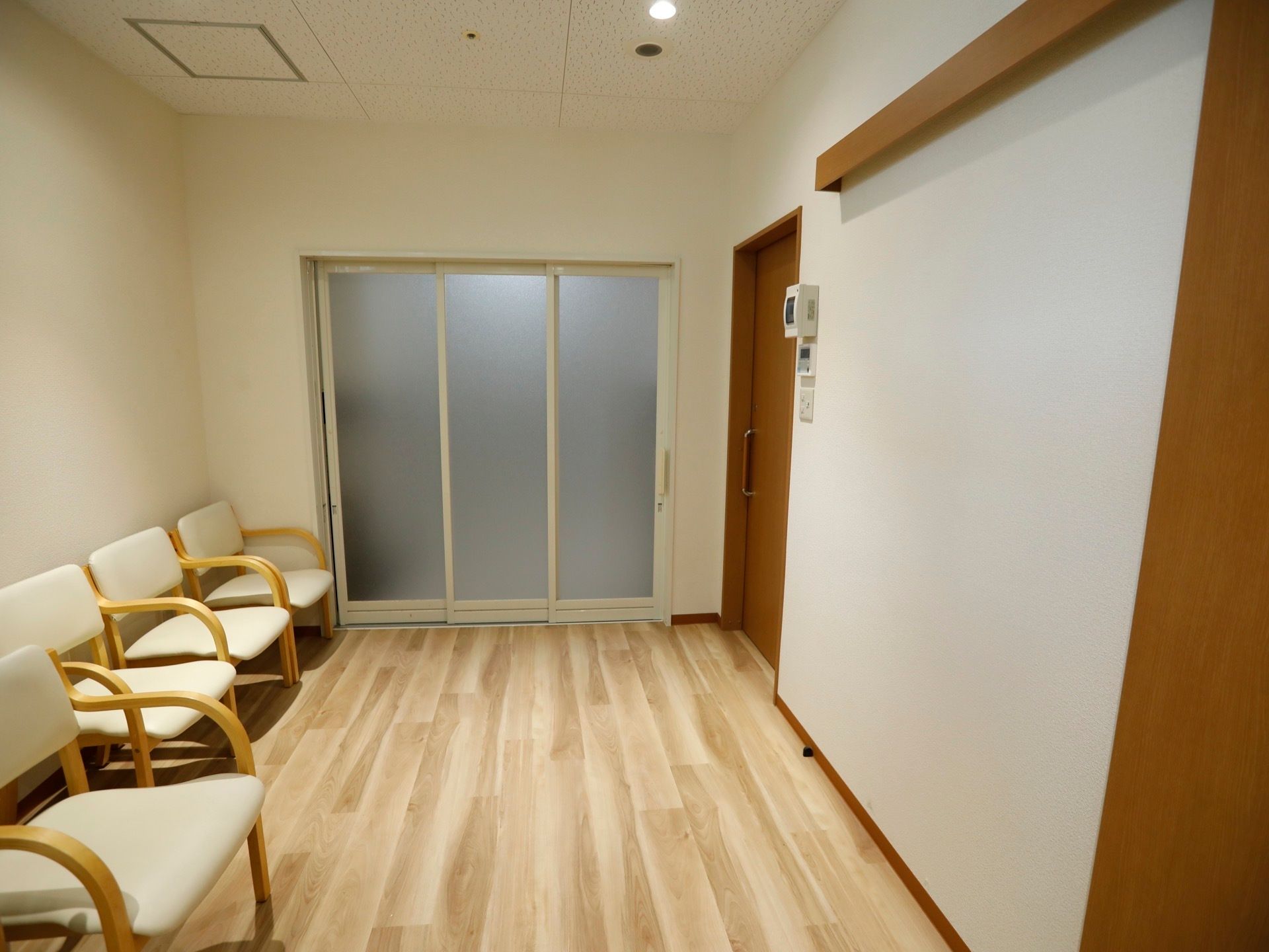 開放的な脱衣所には椅子を用意。床はフローリングが施されており、扉はスライドドアになっている。