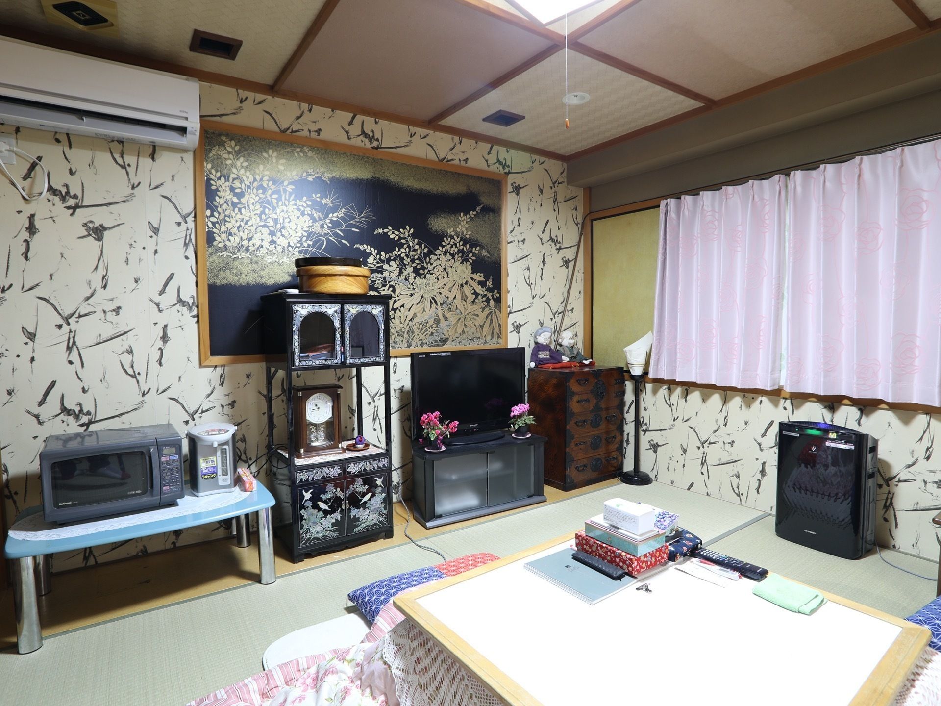 畳敷きの居室は、壁紙、天井、照明など、和のテイストになっている。こたつやテレビなどの電化製品や、和の調度品が置かれている。
