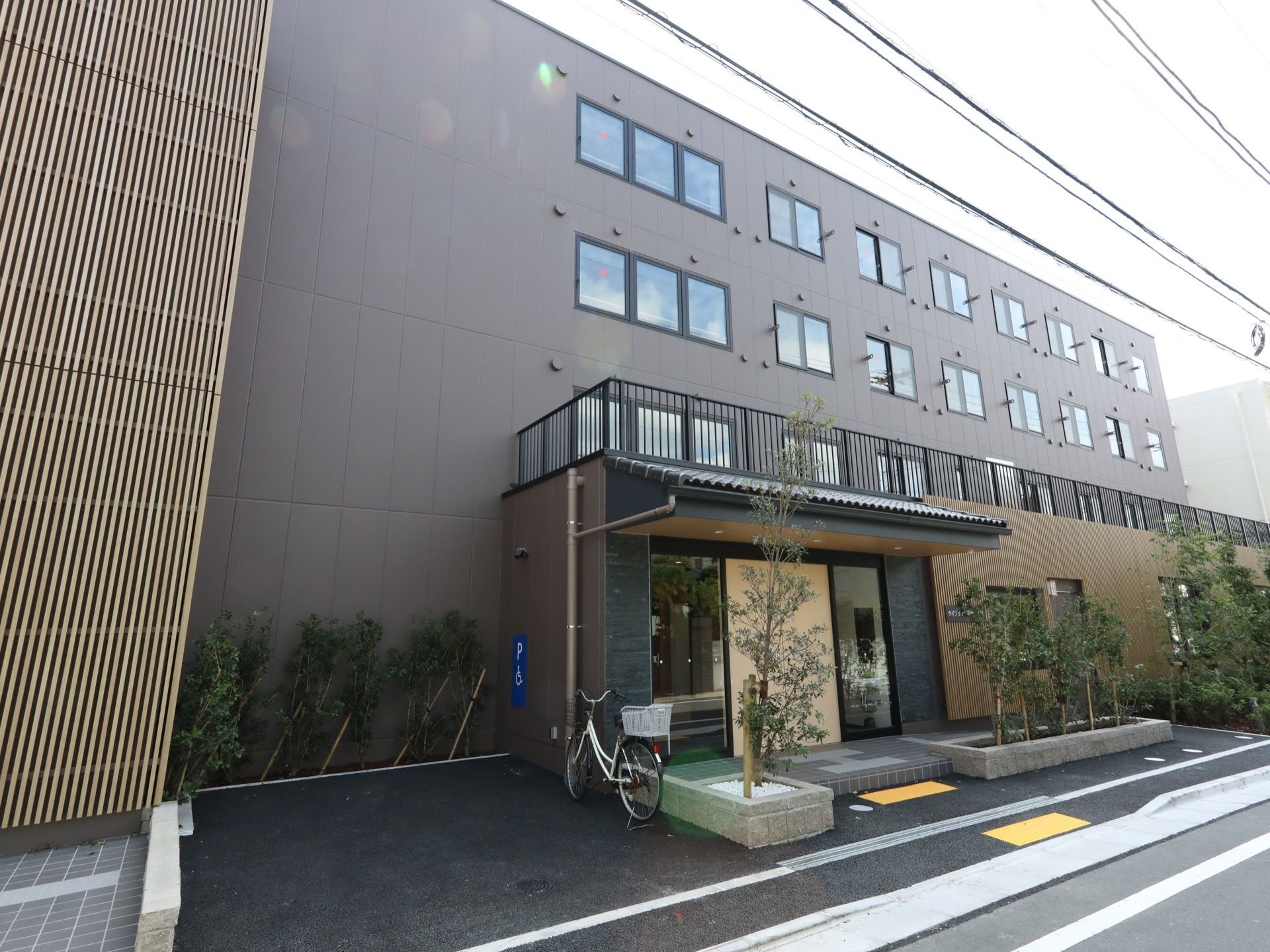 施設は4階建てになっており外壁はダークグレー色である。建物の前には木々が植えられており、自然に親しむことができる。