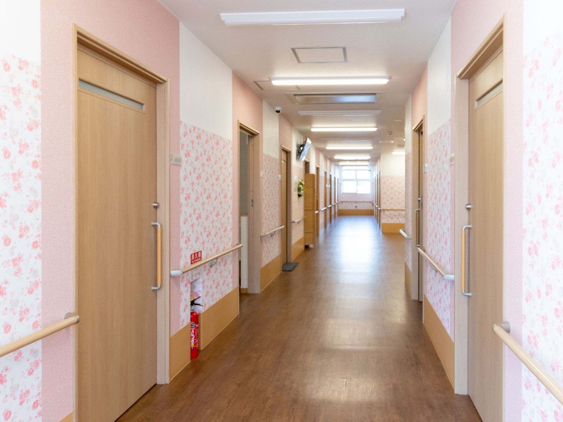 楽しそうに話している高齢女性たちの輪に白衣を着た女性スタッフが混じっている。