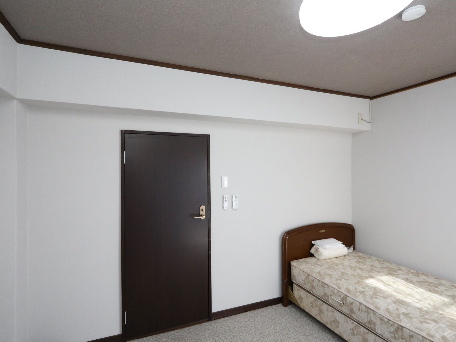 白い壁で囲まれた洋風の居室である。ベッドが１台置かれており、ドアは鍵付きとなっている。また、ドア横の壁にはリモコンが取り付けられている。