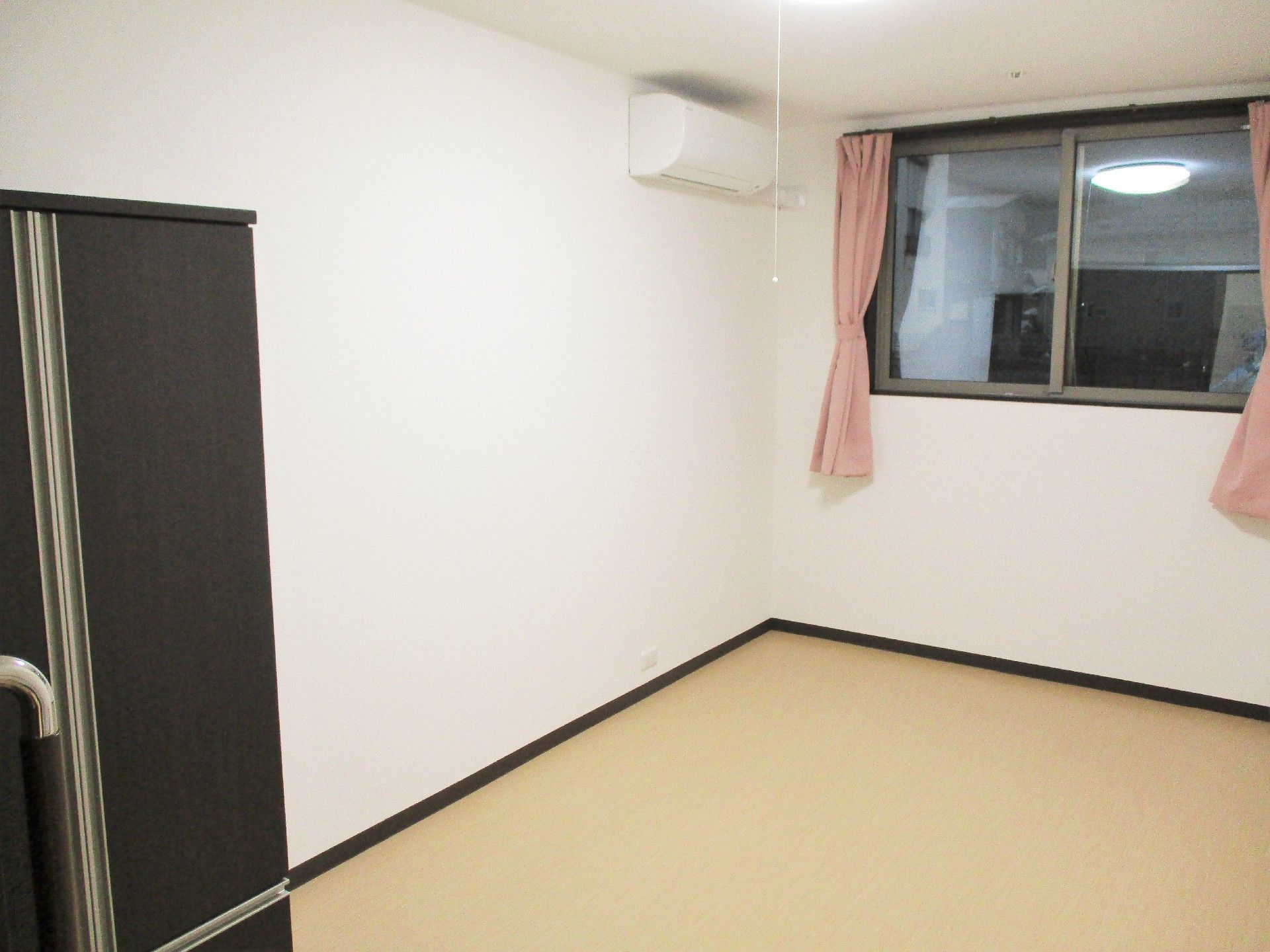 窓やエアコンが付いたシンプルな居室。私物はまだ持ち込まれていない。