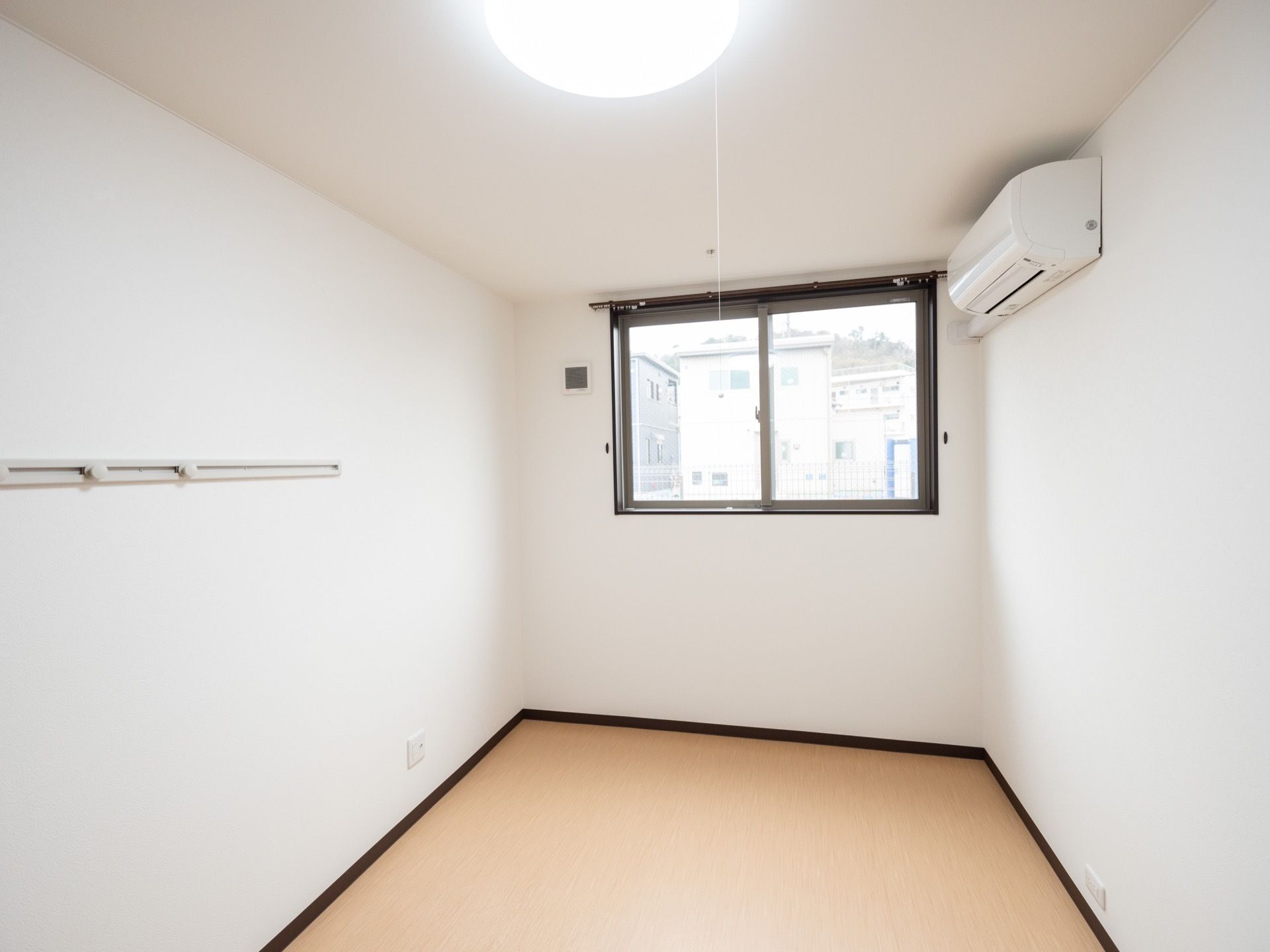 白で統一されたシンプルな居室である。エアコンとLEDライトが完備されている。好きな家具が持ち込み可能である。