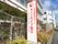 赤い縁で赤い文字で施設名が書かれている看板