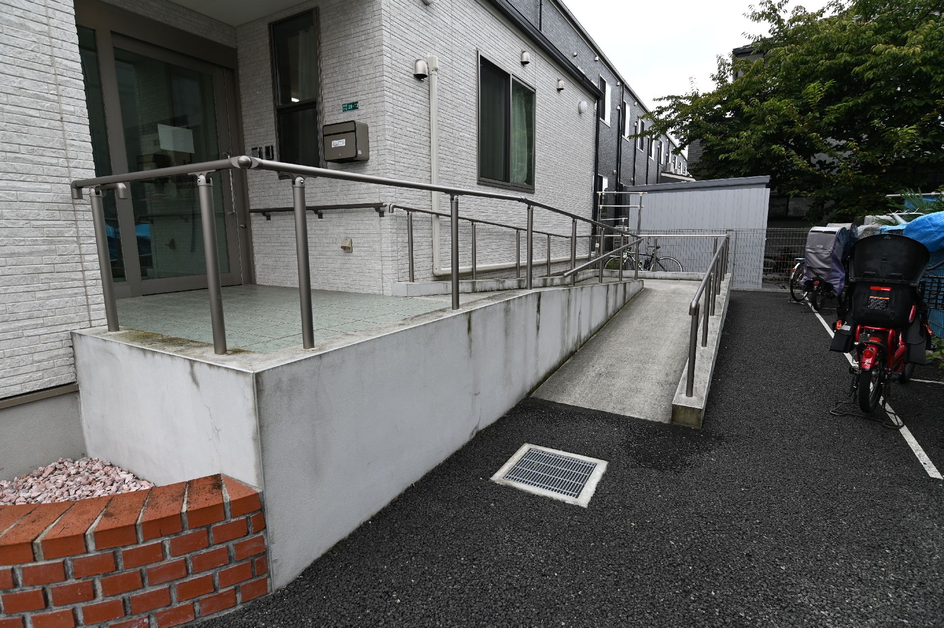 屋外で車いすの高齢女性と付き添いの高齢男性を中心にして若い男女のスタッフが立っている。4人とも笑顔。