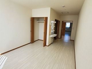 車いす対応の洗面所や木製のドアが付いたクローゼットが付いたフローリングの部屋には、家具はまだ置かれていない。