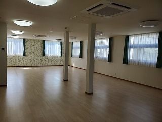 フローリングの共有スペースにはカーテン付きの窓がたくさんあり、家具などは置かれていない。
