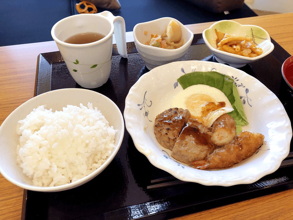 白いご飯にみそ汁、あえ物や煮物、エビフライやハンバーグなどボリュームがある献立。