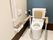 一人用のトイレの様子。立ち上がり用の手すりと洗面台がついたタイプ