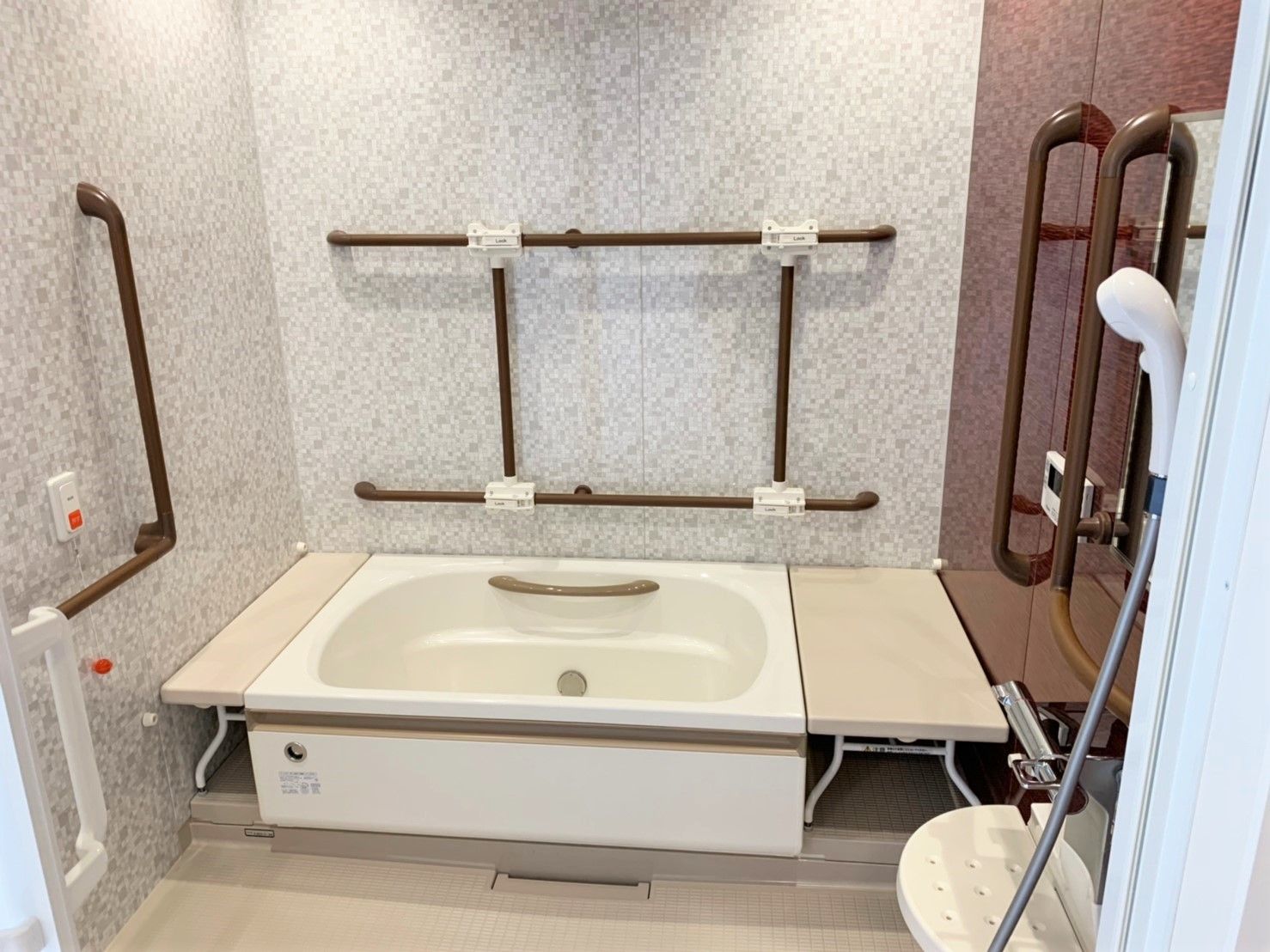網目型の手すりがついている浴室の様子。座ったまま姿勢を変えられる腰掛がついている浴槽の様子