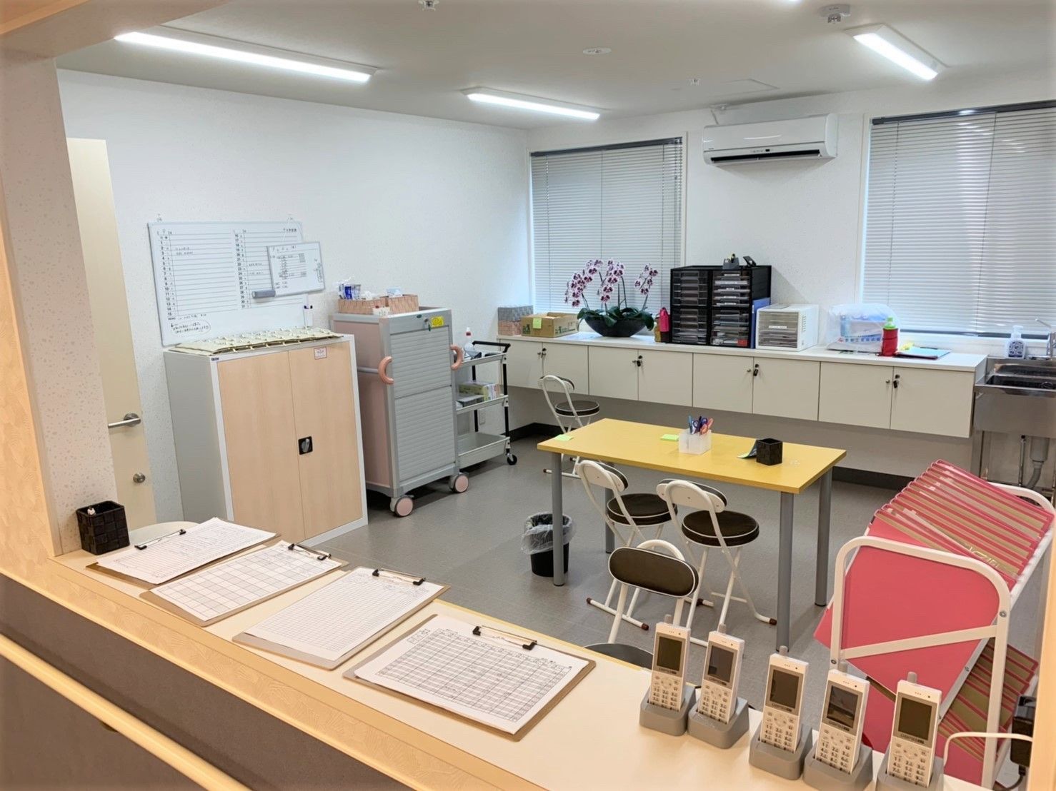 カウンターにはPHSがずらりと並び、中央にテーブルセット、各入居者の情報が入ったファイルもある。