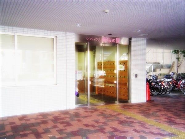 自動ドアが付いたエントランスの周りにはレンガブロックが敷かれ、中に入ったところには靴箱が設置されている。