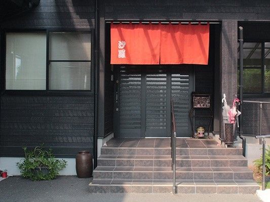 施設苗の会談スペースの写真。手すり付きの階段と暖簾が写っている様子
