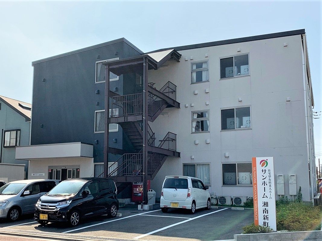マンション風の建物と駐車場スペースが写っている写真。高齢者向け住宅の外観