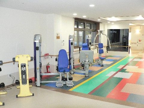 カラフルなフロアーに設置されている複数のリハビリ機器