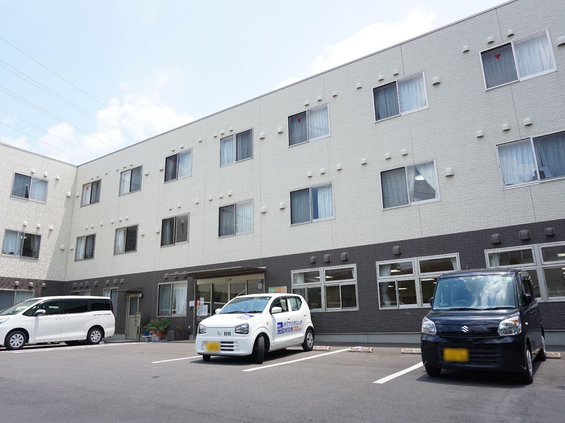 アスファルトで整備され、数台の車を止めることができる施設の駐車場