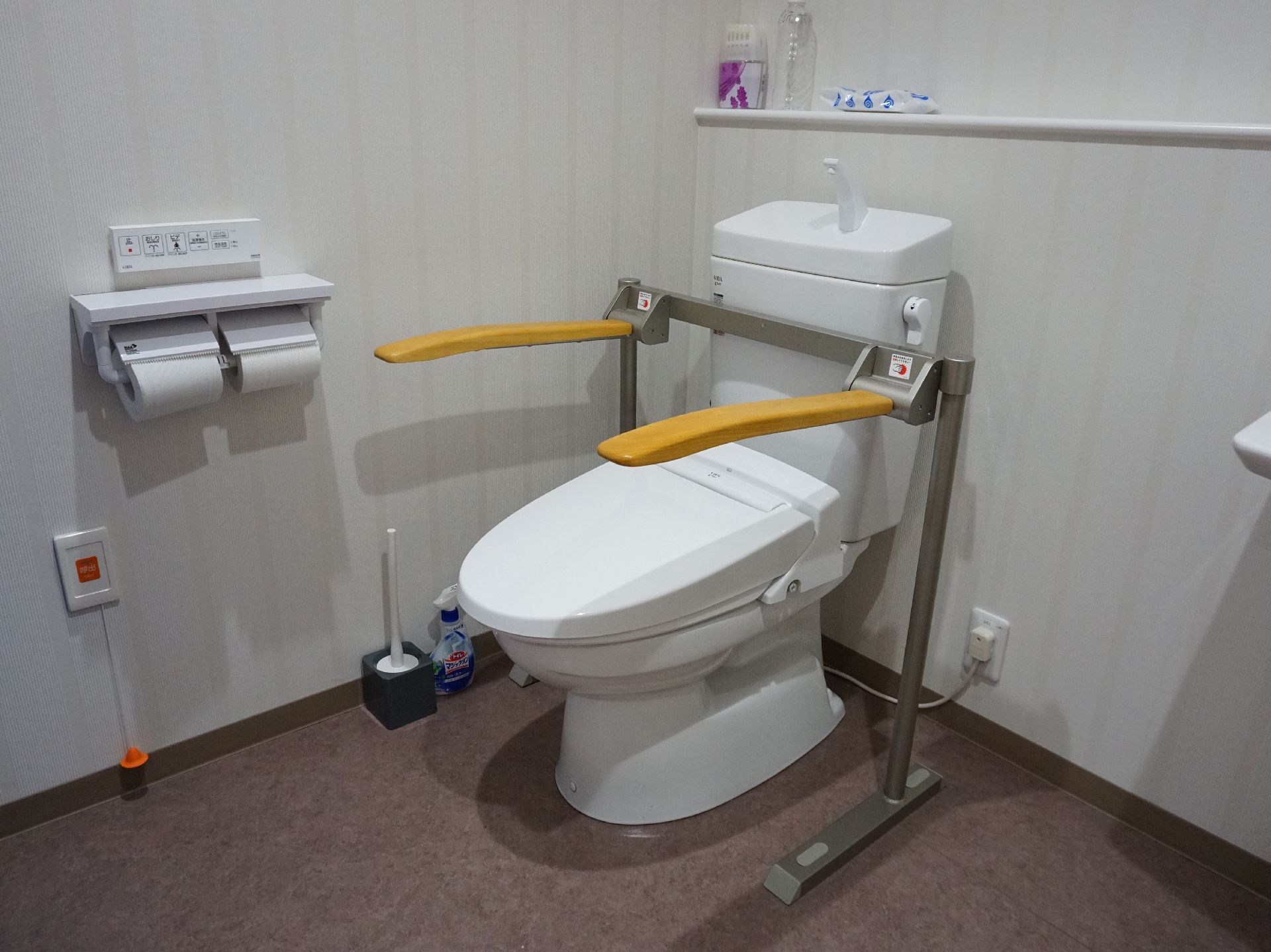 床には段差がなく、便座に手すりが取り付けられているトイレ