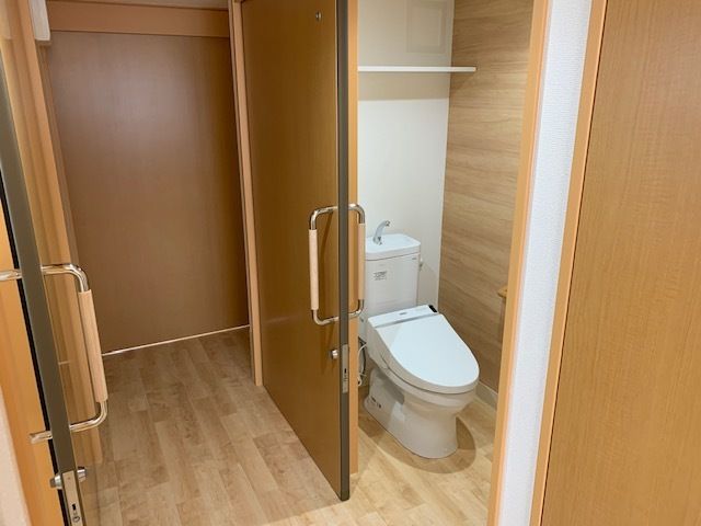 トイレは引き戸で棚が付いていて、シンプルなデザインの洋式で、介助スペースもある。