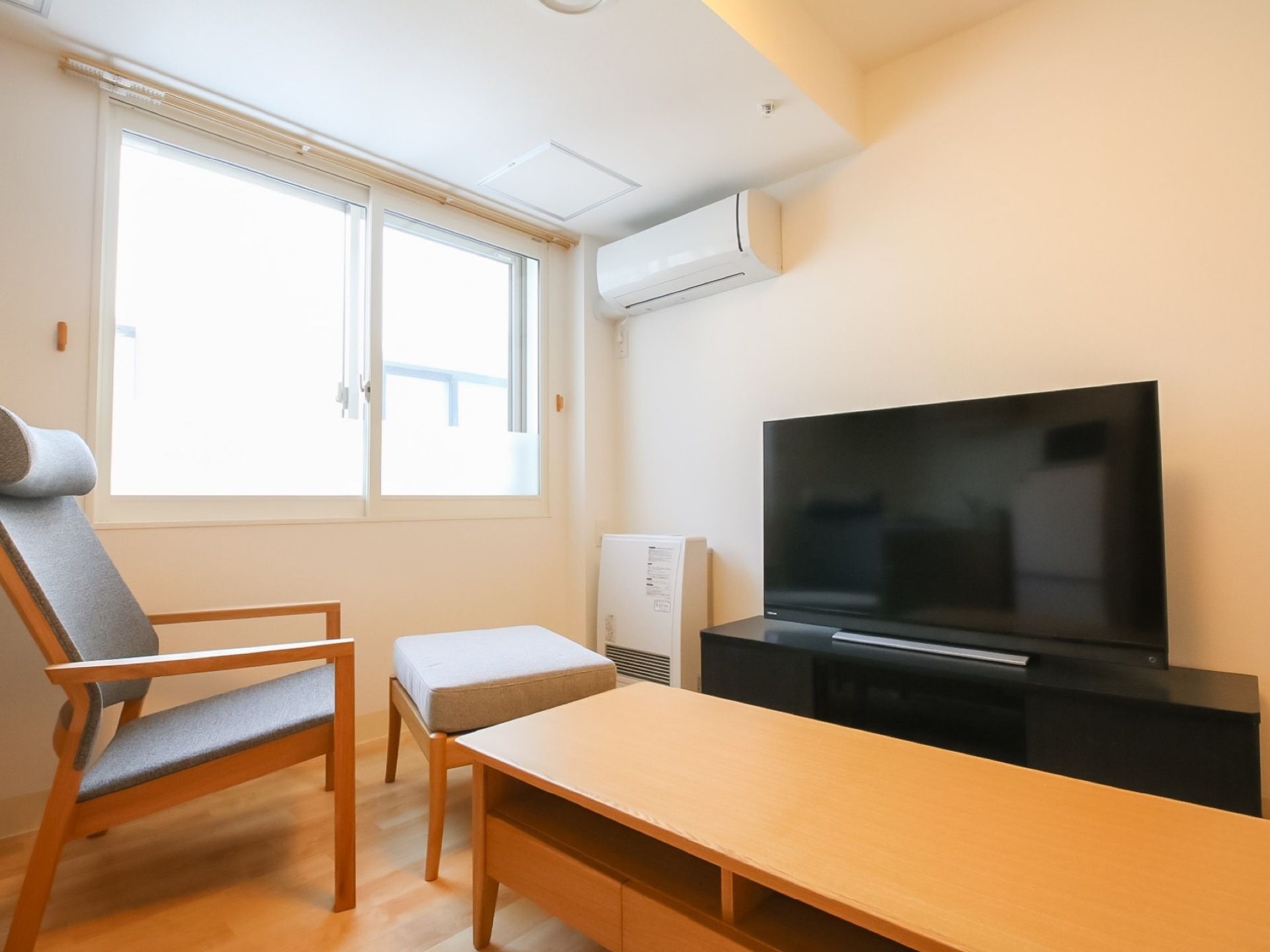 窓から美しい外の景色が堪能できる居室である。足置きのあるソファに腰かけて、大画面のテレビを観ながら優雅に過ごすことができる。