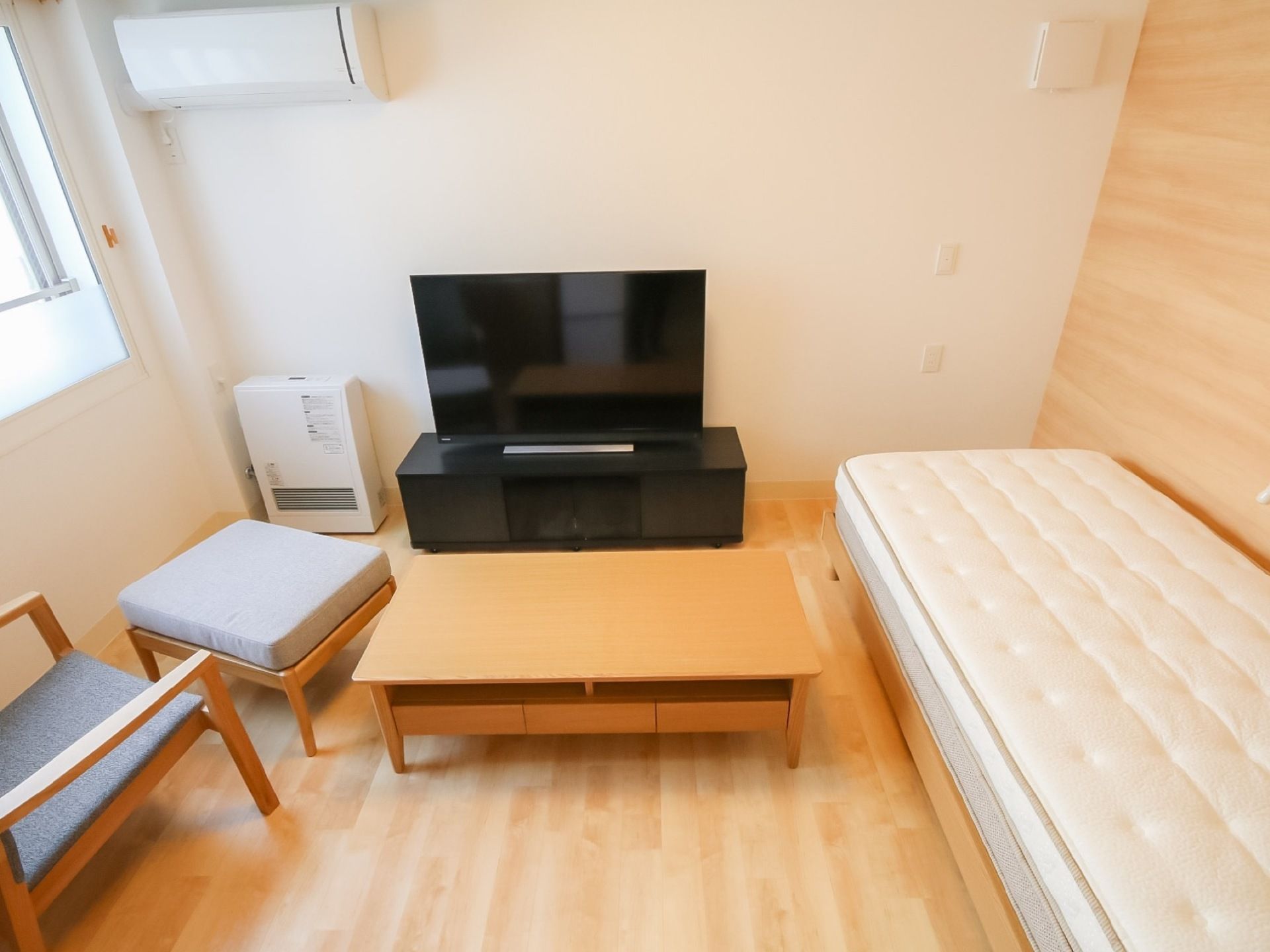 日当たりが良く、温かみのある居室である。部屋の中央には大型液晶テレビが置かれ、周りにベッドやソファが備わっている。