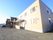 ベージュ色の２階建ての建物である。玄関部分はダークブラウンに塗り分けられている。外壁に沿ってスロープがある。