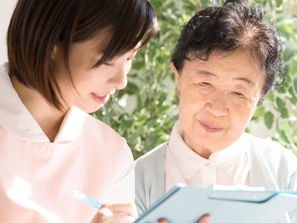 高齢女性と会話する女性ケアマネジャー