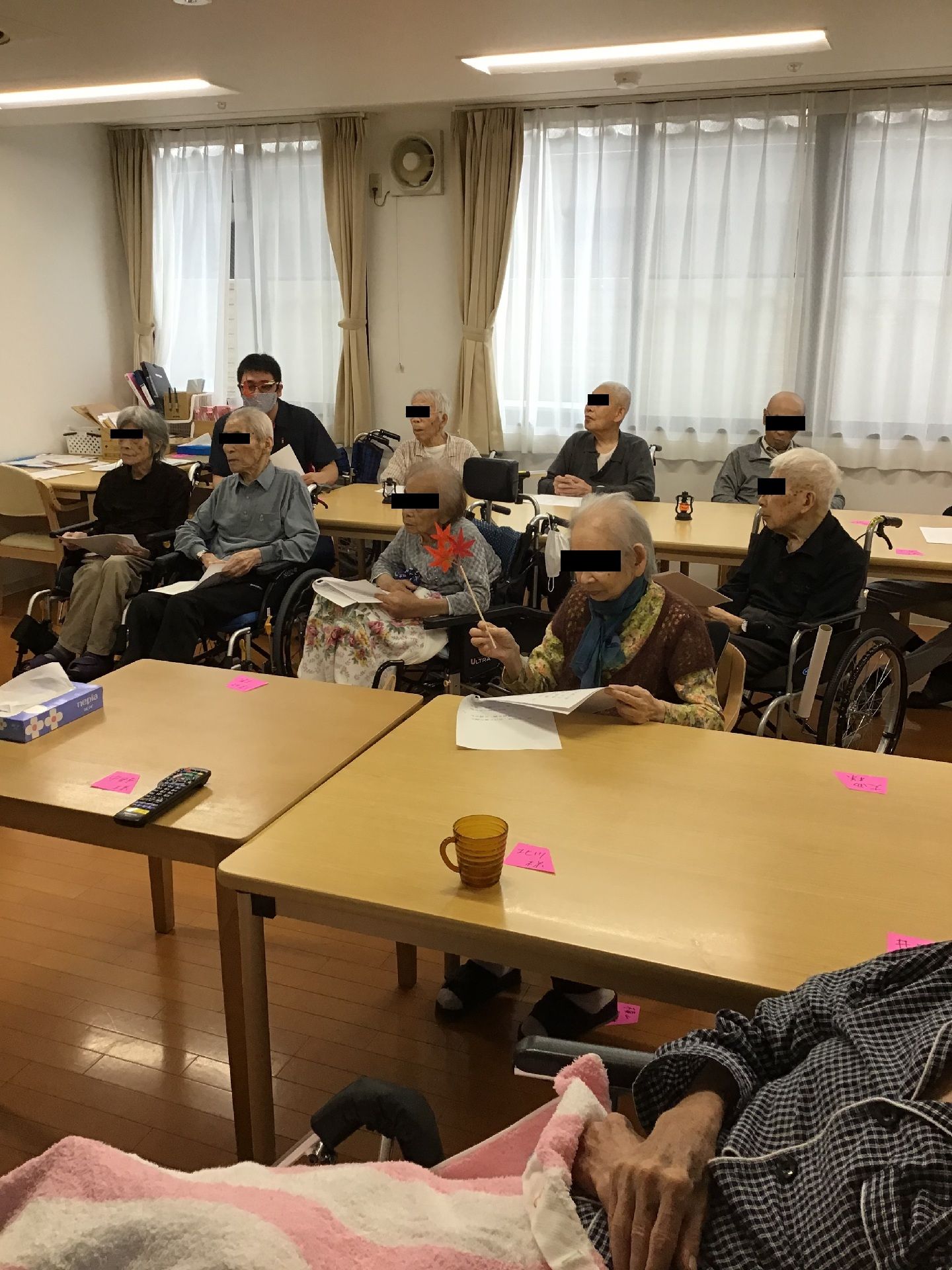 共有のスペースで紙を持ち読んでいる人たちが多くいる
