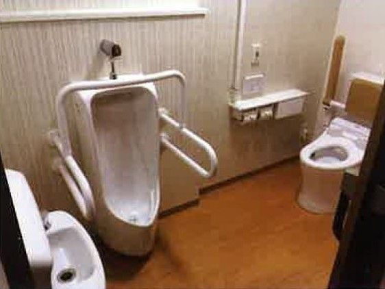 男性用トイレや手洗いが付いたトイレ。温水便座が付いたトイレにそばに操作パネルもある。