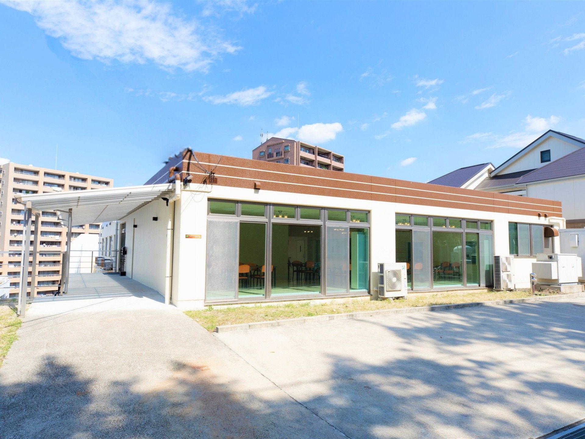 とても日当たりのいい平屋建ての施設である。建物のすぐ横に駐車スペースがあり、車が何台か停まっている。
