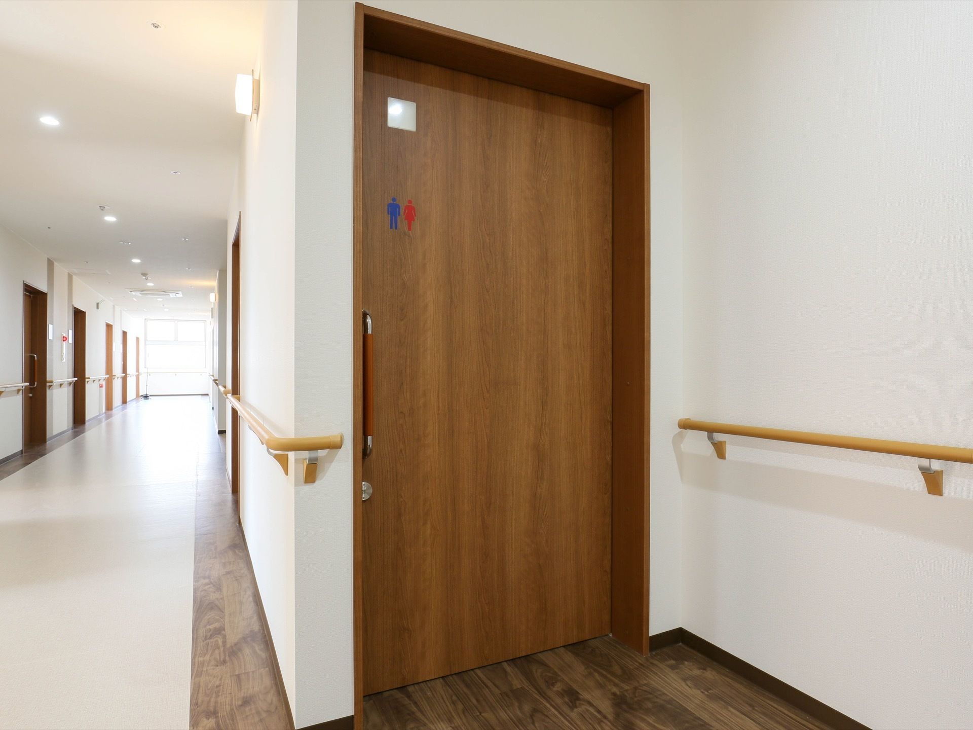 廊下に設置されたトイレは、扉が木製の引き戸になっている。廊下の壁には手すりが付いており、床はリノリウムになっている。