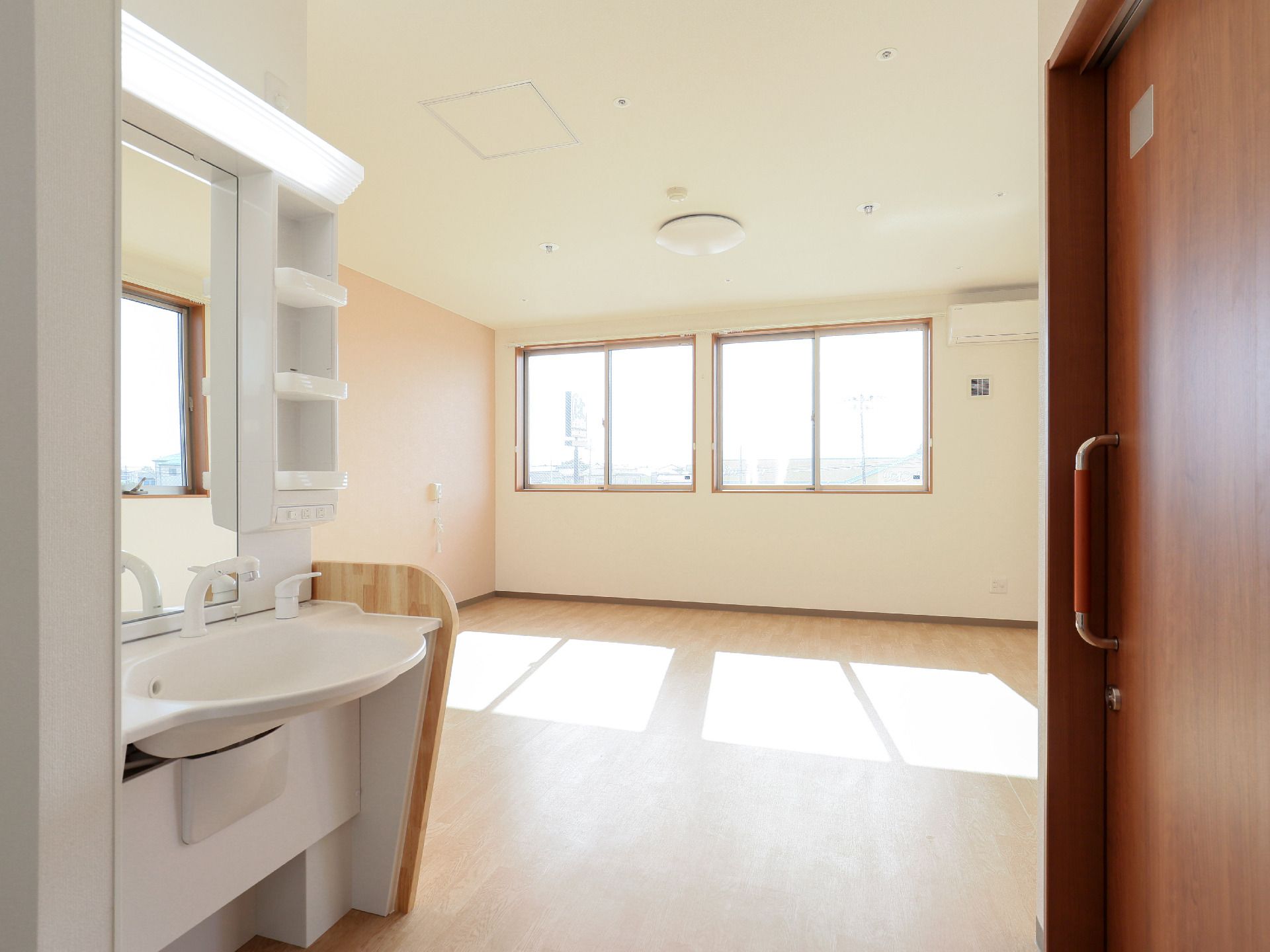 腰高窓が２つあり、居室内にエアコン、独立洗面台が設置され、トイレがある個室