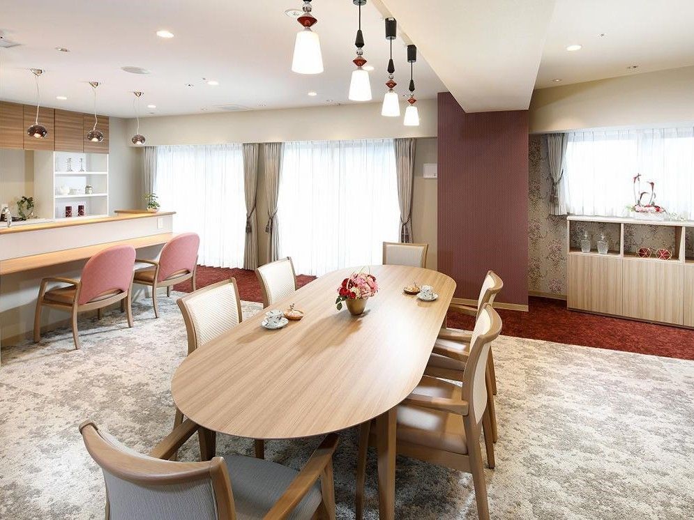 6人着席可能な大きなテーブルとカウンター付きキッチンのある広い部屋