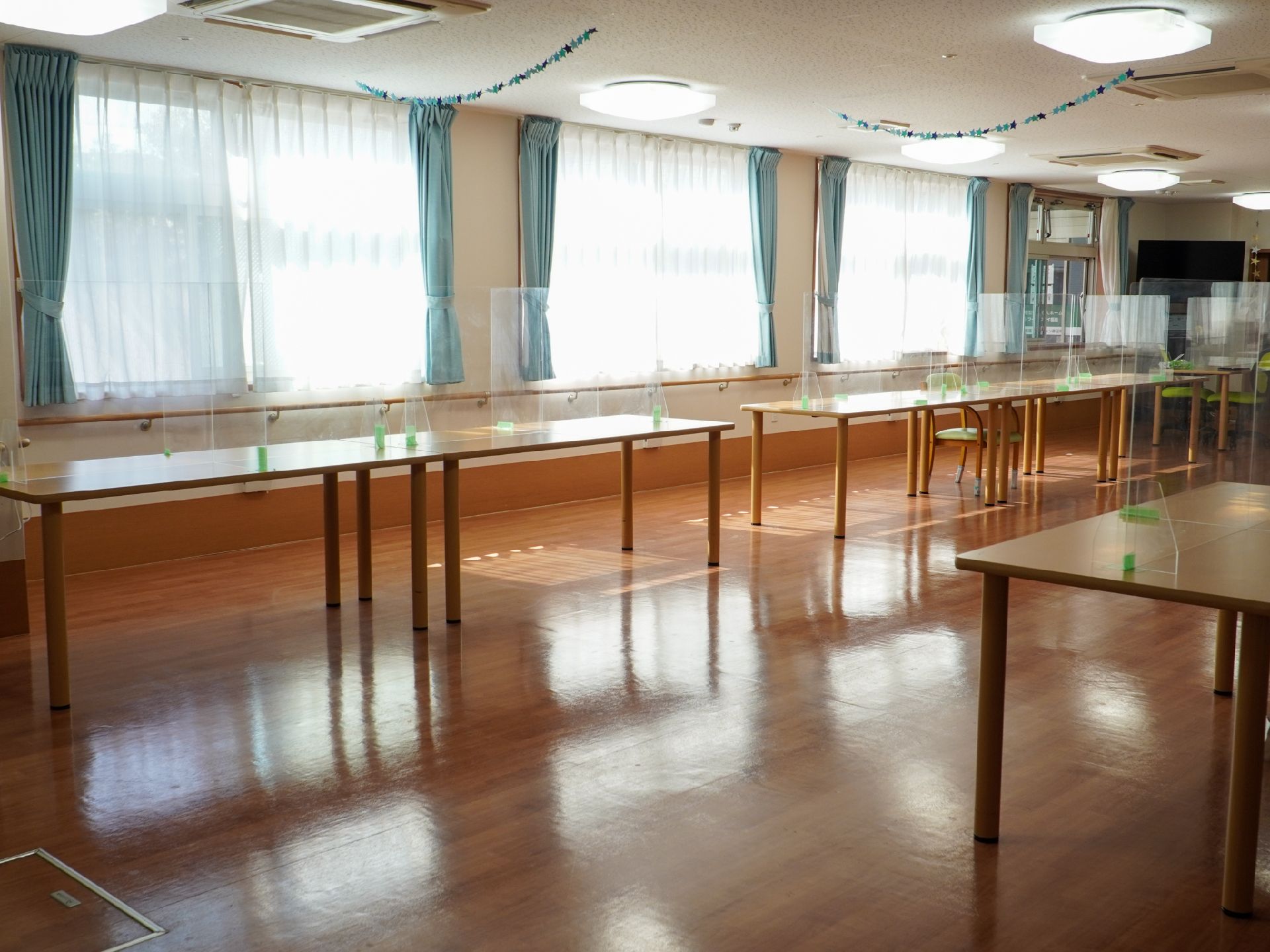仕切り板がついているテーブルが設置された共有スペース