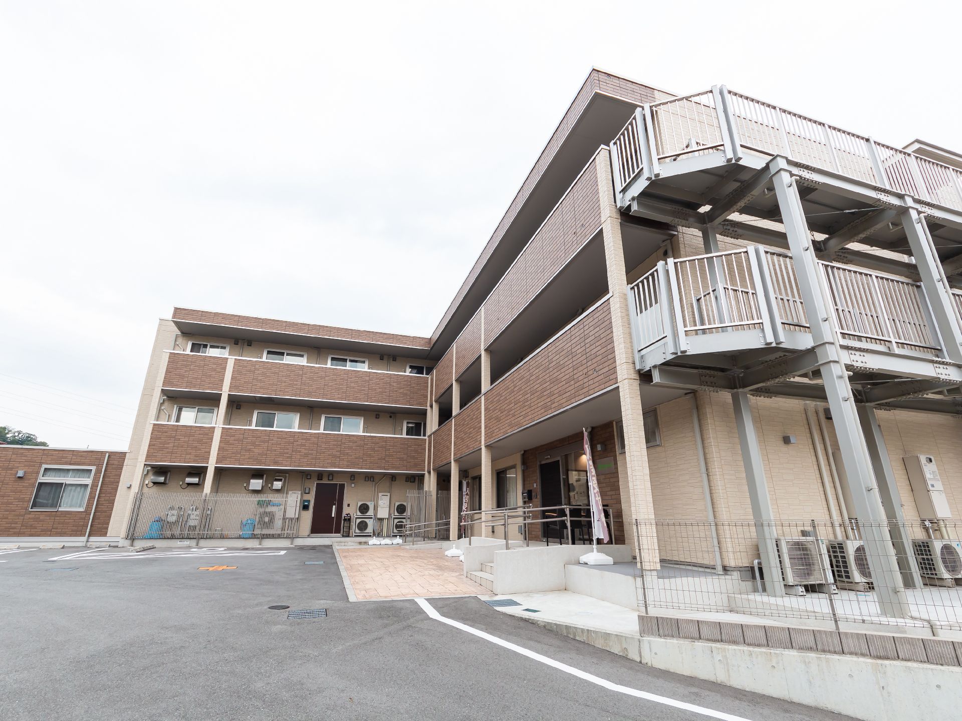 坂道の近くに立地する３階建ての茶色い建物