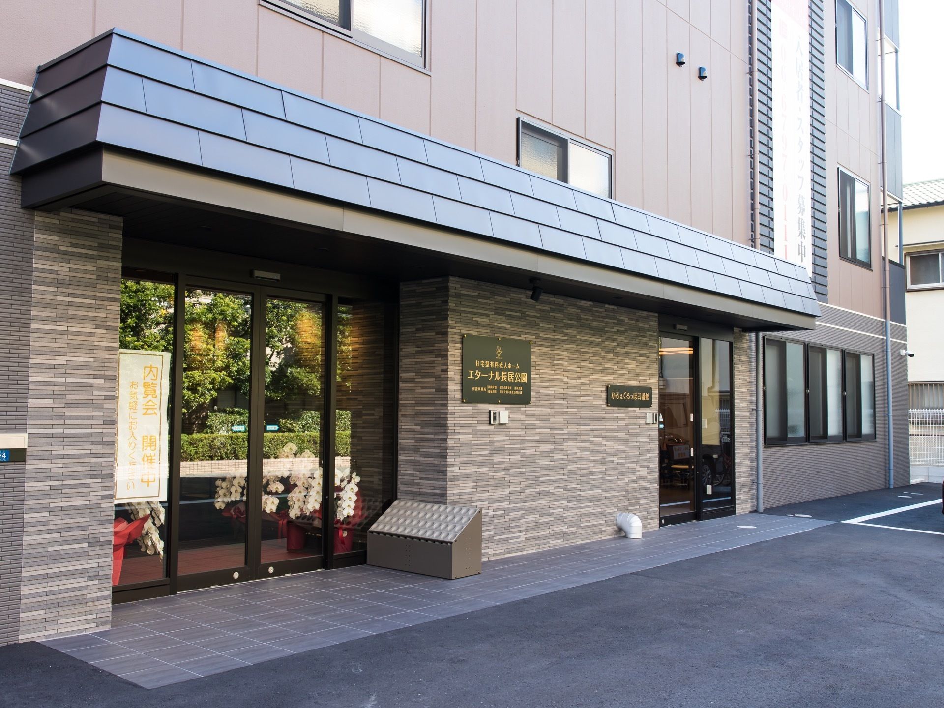 ガラス張りの自動ドアが２つ設置されている建物である。駐車場から館内までのアプローチには段差がないつくりになっている。
