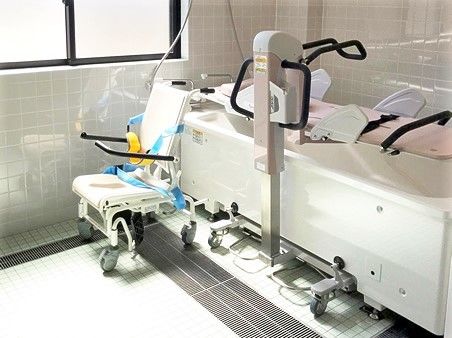 白とピンクの機械浴が置かれたタイル張りの浴室。介護度が高い人も入浴できる。