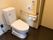 ナースコールが完備されている、清潔感のある個室トイレである。温水洗浄機能付きの便座が採用されている。