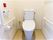 両側に手すり、壁に緊急コールが取り付けてある施設内のトイレの様子